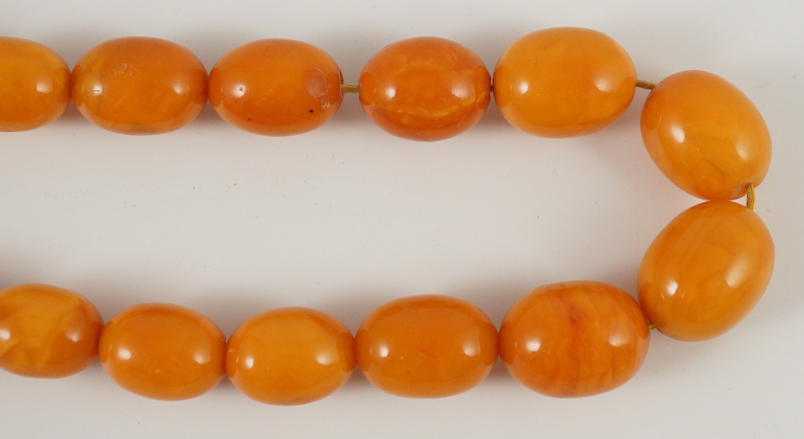A single stand graduated oval amber bead necklace, 76cm, gross weight 85 grams.